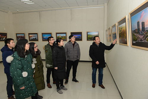 圖為觀眾在交流欣賞明光城市建設圖片.jpg